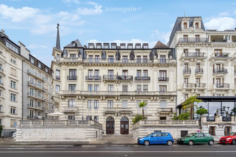 A large, elegant multi-story building with ornate architecture, multiple balconies, and a central entrance. The building features classic European design with detailed stonework and large windows.