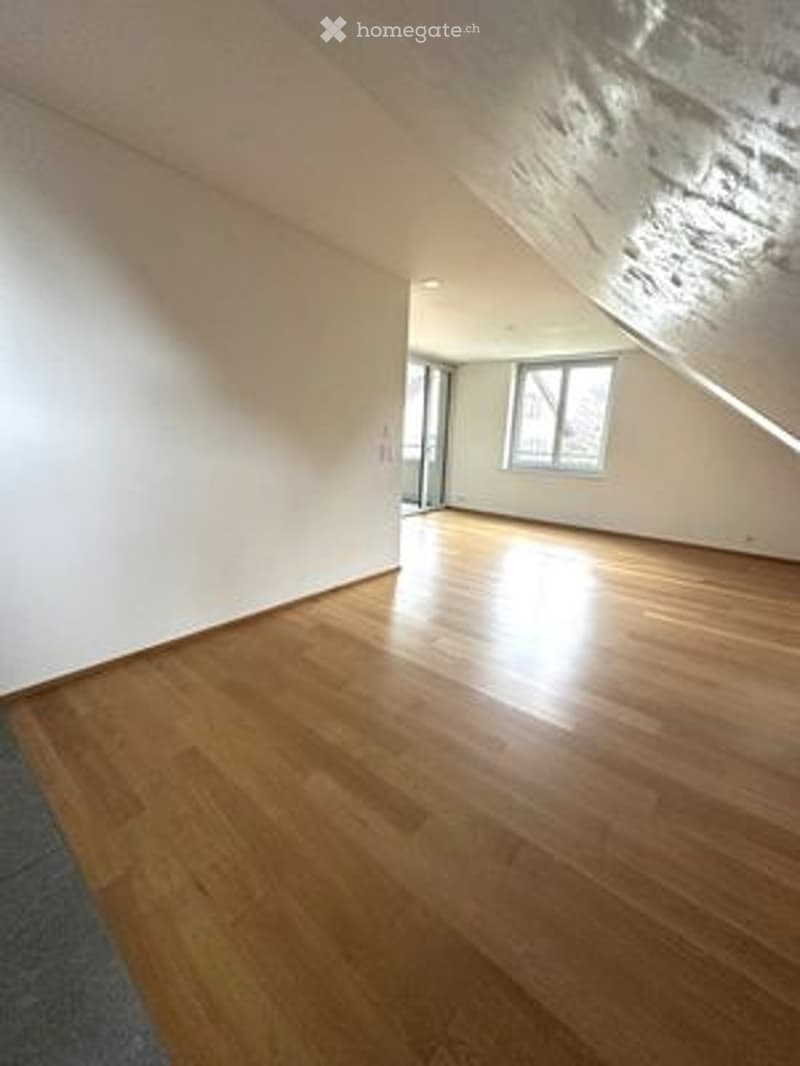 Completely empty room with wooden flooring and white walls. No furniture or equipment.