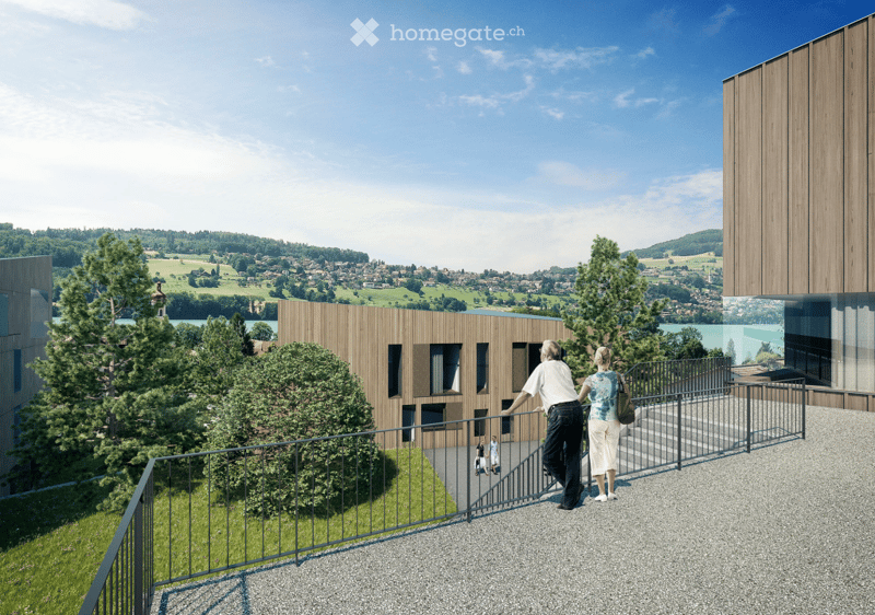 Balcony overlooking a scenic landscape with a modern building and distant town view.