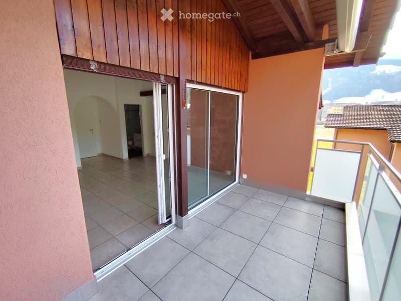 Balcony with sliding glass doors, tiled floor, wooden wall, view of the outside