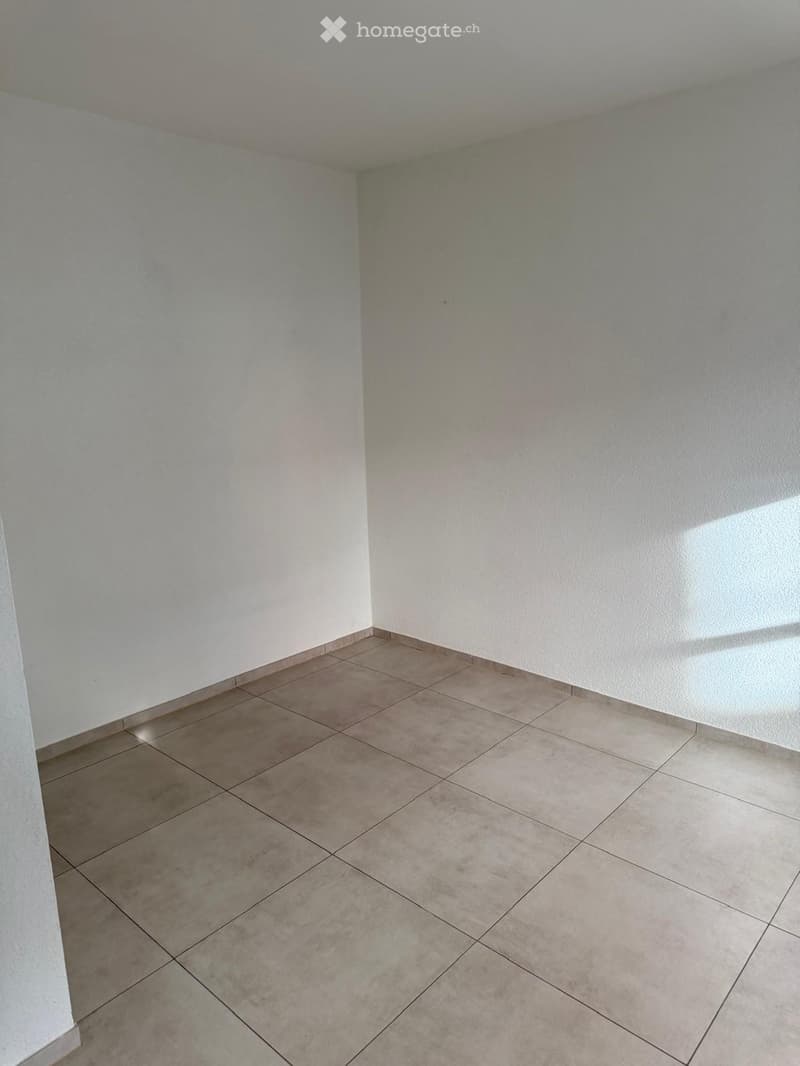 Empty room with tiled floor and white walls, no furniture or equipment visible.