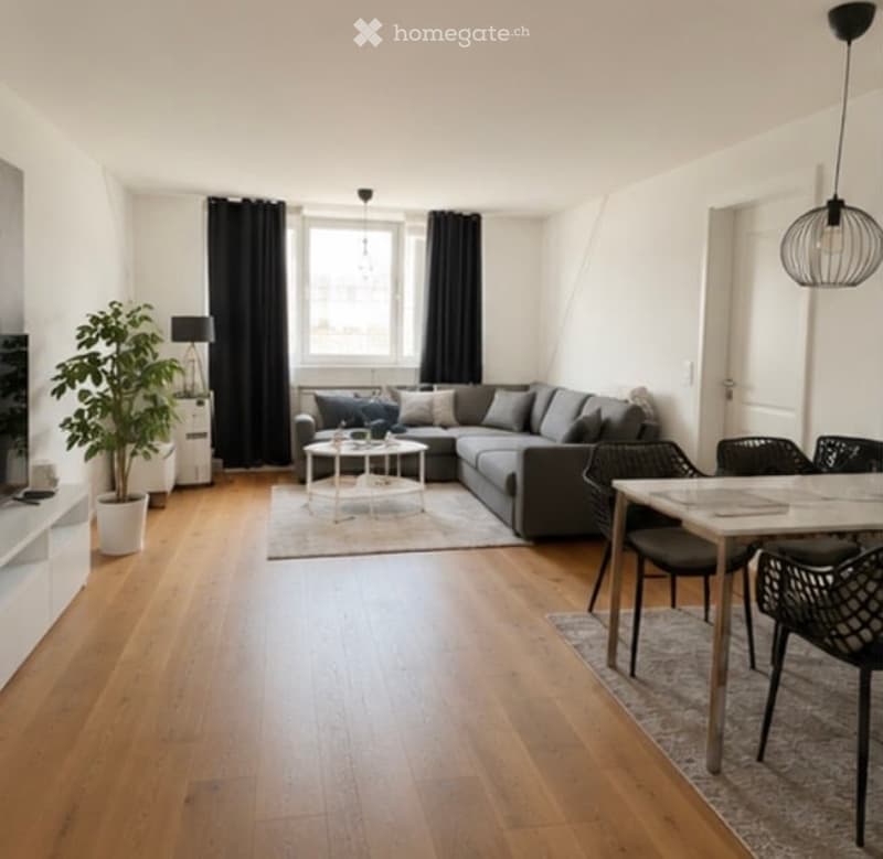 Modern living room with hardwood flooring, large window with black curtains, grey sectional sofa, coffee tables, dining area with chairs and table, potted plant, and wall-mounted TV stand.