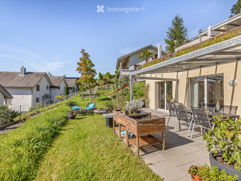 Garden area with a patio, seating area, and lawn. Includes a wooden garden bed, potted plants, and outdoor furniture.