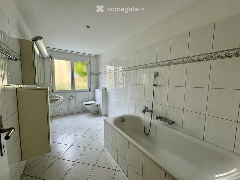 Bathroom with bathtub, sink, toilet, and shower head