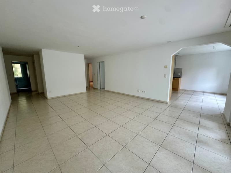 Empty room with white walls and tiled floor, power outlets, and doors leading to other rooms