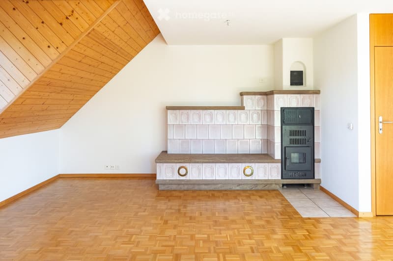 Modern room with wooden herringbone flooring, white walls, and a built-in fireplace with a wooden bench and decorative tiles.