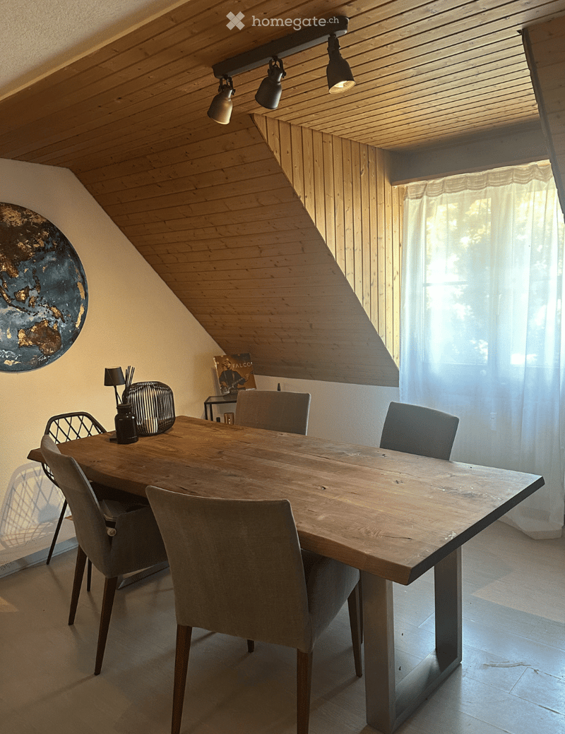 Modern dining area with a large wooden table, six chairs, and decorative items including a globe and a lamp.