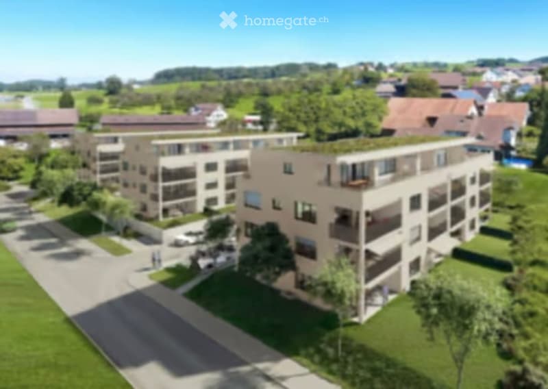 A modern multi-story residential building with balconies and large windows, surrounded by green lawns and trees.
