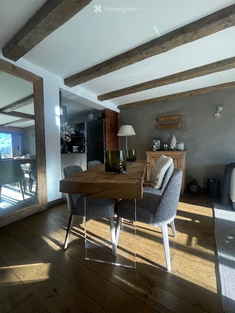 dining room with wooden floor, wooden beams, dining table, glass chairs, lamp
