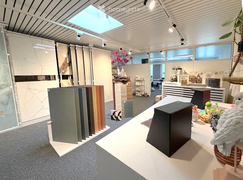 Interior showroom with a variety of sample boards, a table with decorative items, shelves, and a display cabinet.