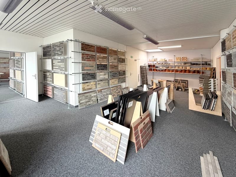 A showroom with various tiles and materials displayed on shelves and racks, including brick, wood, and ceramic samples.