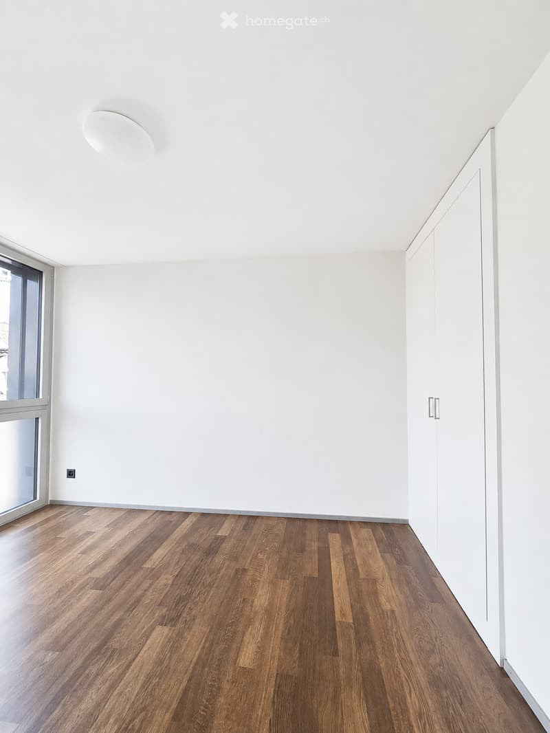 Completely empty room with bare white walls and wooden floor. No furniture or equipment.