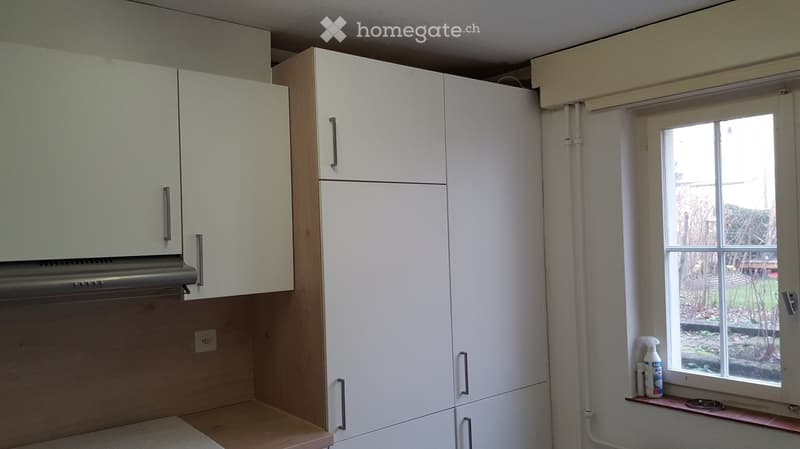 White cabinets, electrical outlet, white walls, white windows, bottle