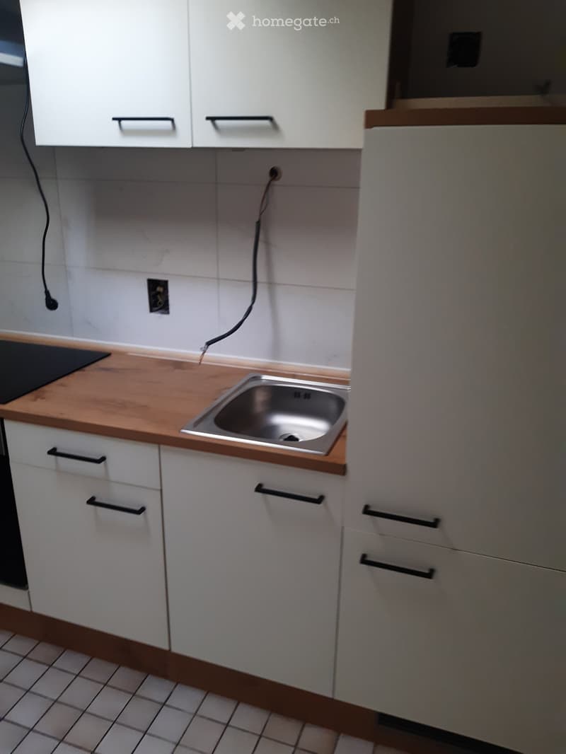 kitchen with white cabinets, wooden countertop, stainless steel sink, tiled floor, electrical outlets, black stovetop
