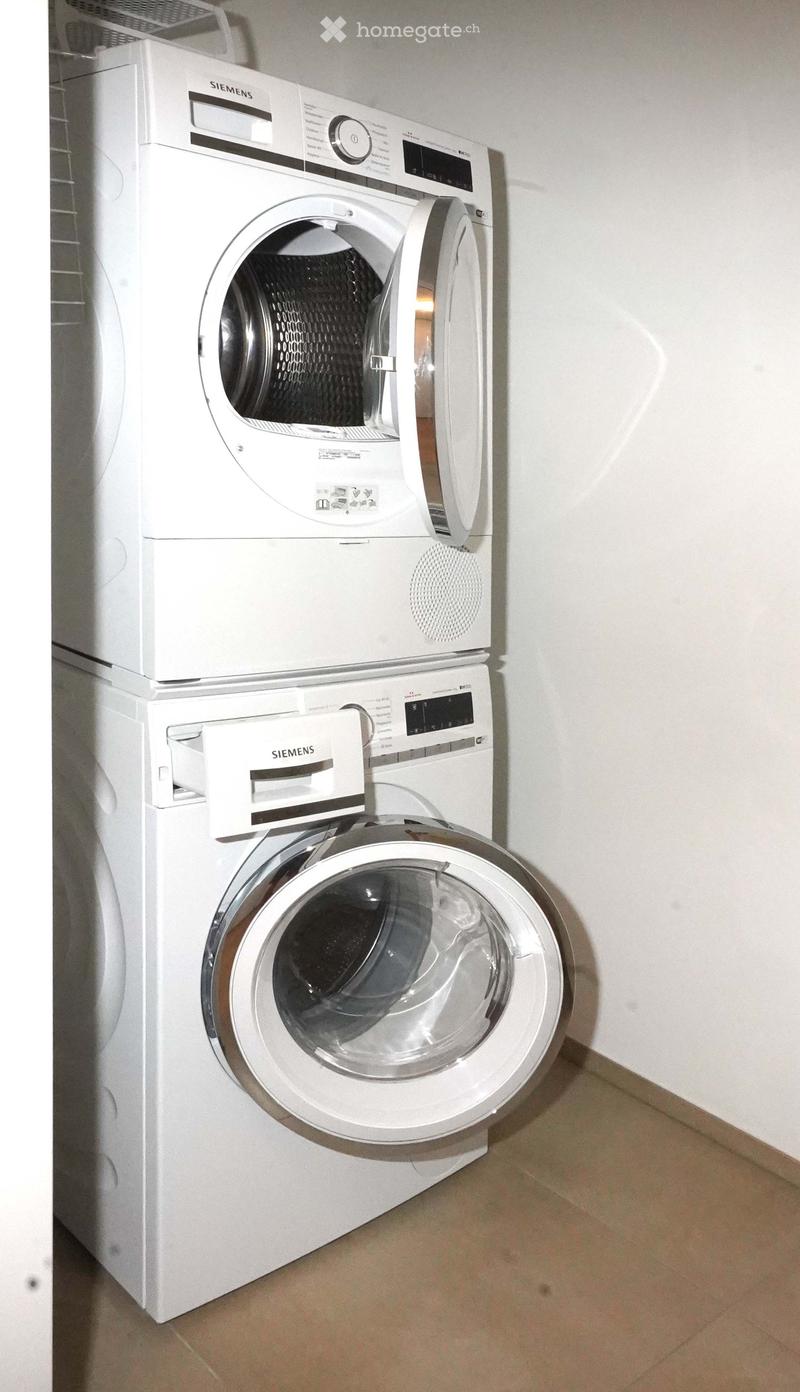 Two white Siemens washing machines stacked vertically, one above the other, with control panels and open doors.