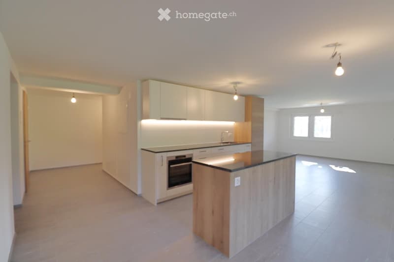 Modern kitchen with white cabinets, a central island, and built-in appliances including an oven and sink.