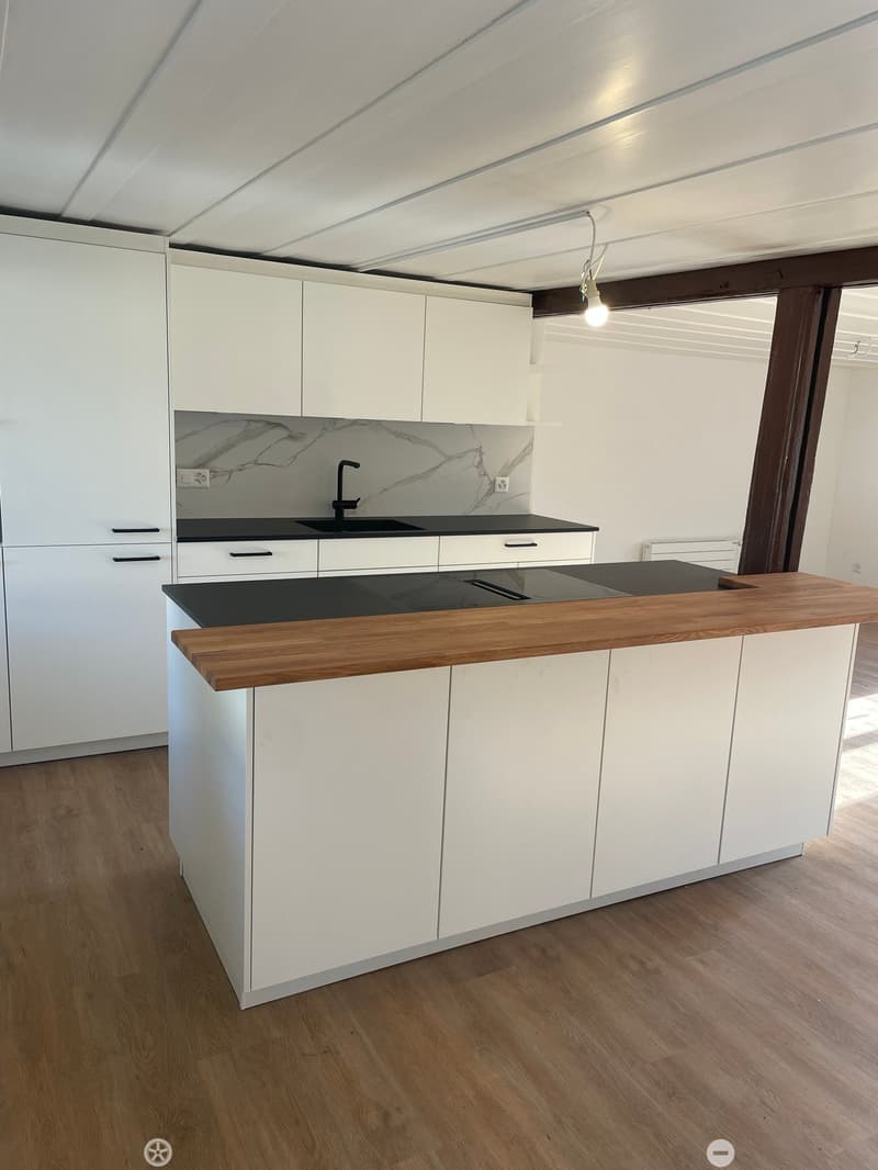 Kitchen. Modern kitchen with white cabinets, a wooden countertop, and a black sink. The backsplash features a marble design.