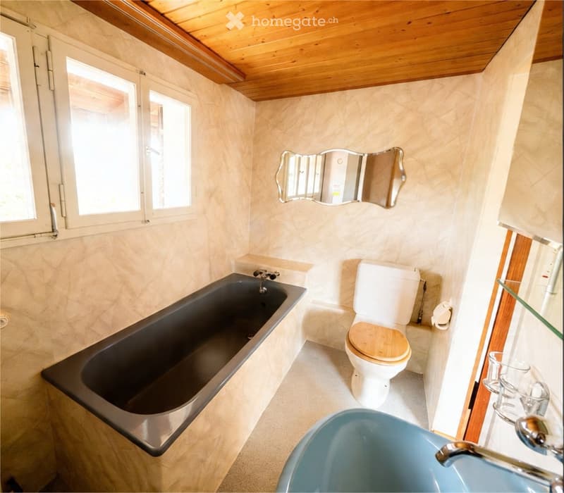 Bathroom with bathtub, toilet, sink, mirror, and wooden ceiling