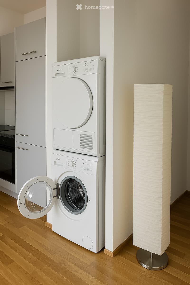 A small, modern room with a white washing machine and dryer stacked vertically, a floor lamp, and a wooden floor.