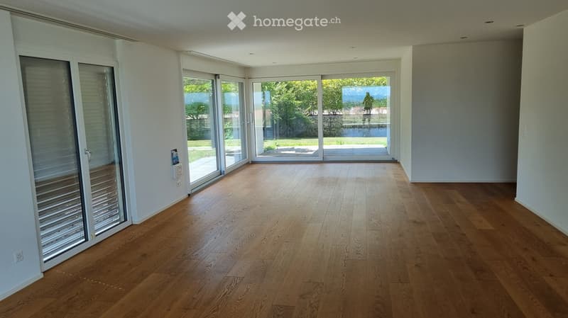 Empty room with wooden flooring and large sliding glass doors leading to an outdoor area.