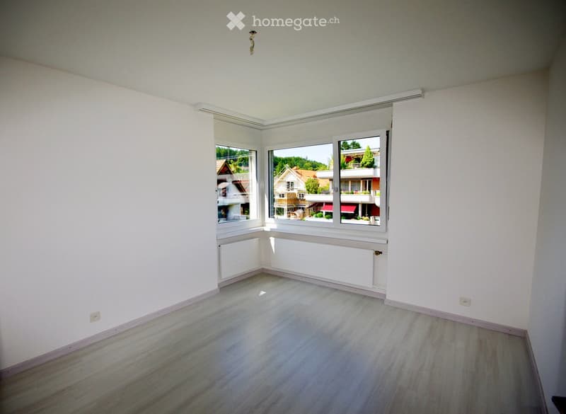 white walls, gray floor, window with view