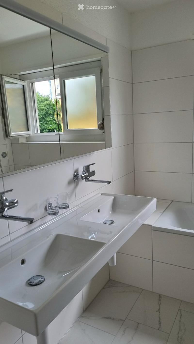 Two sinks, mirror, bathtub, white tiles, glass and plastic cups, faucets