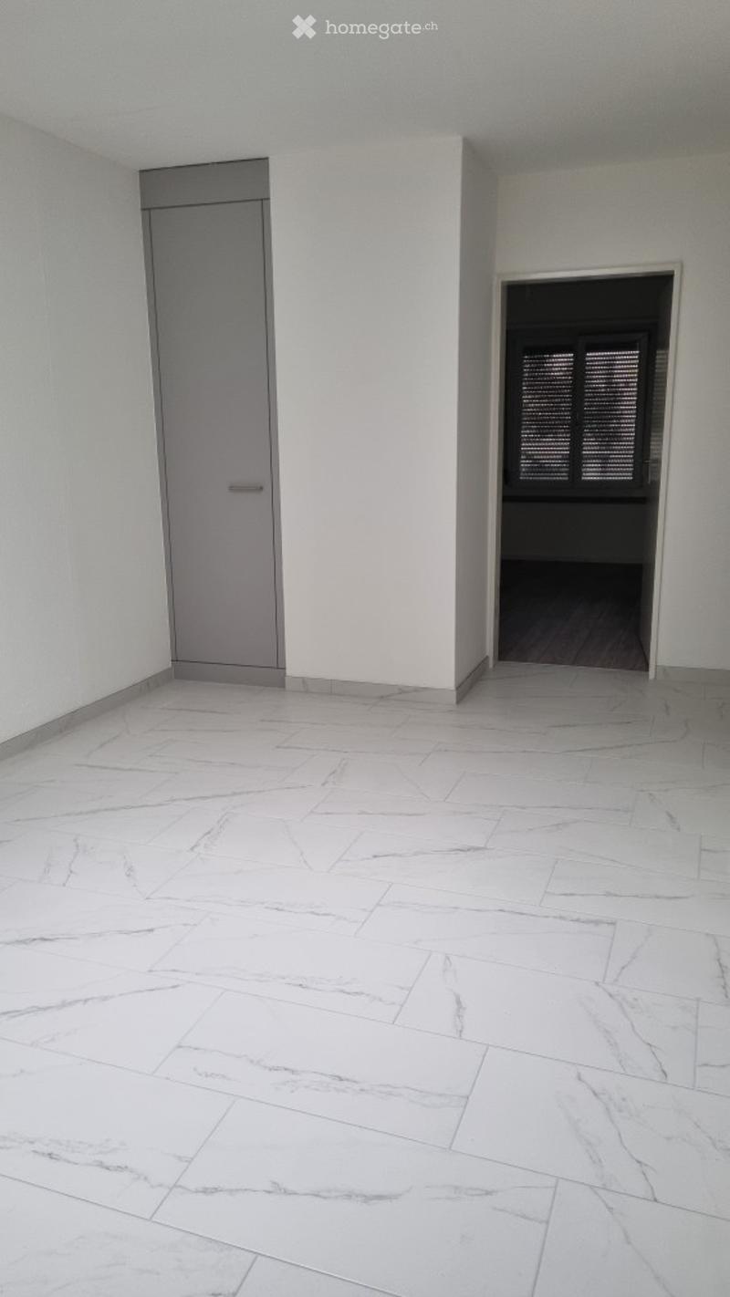 white tiled floor, white walls, gray door, window with blinds
