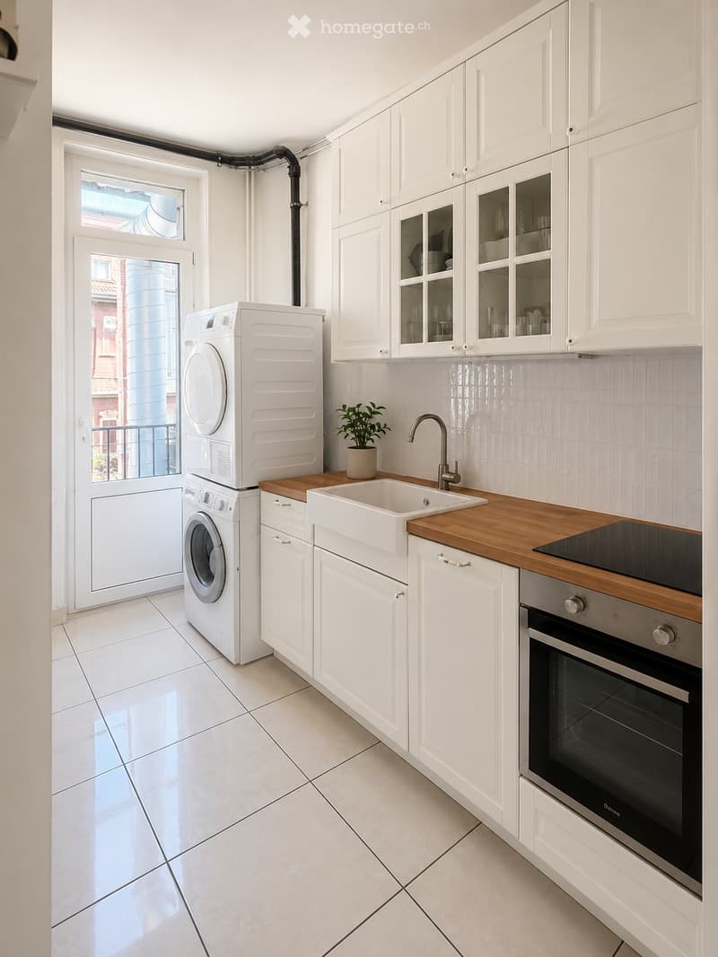 Modern kitchen with white cabinets, a wooden countertop, a sink, a faucet, an oven, a washing machine, and a dryer. A small potted plant is placed on the countertop.