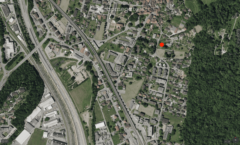 Aerial view of an urban area with residential buildings, commercial structures, and green spaces.