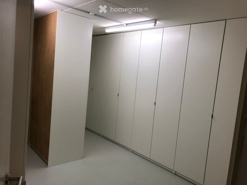 Empty room with white walls, white cabinets, and a light fixture on the ceiling.