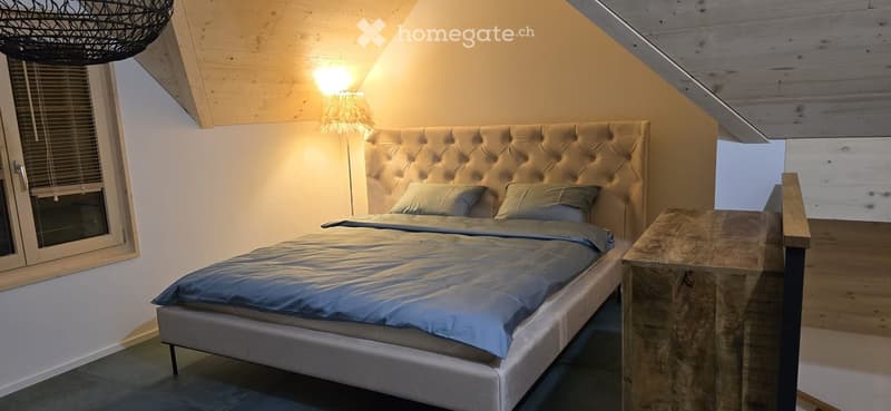 Cozy bedroom with a tufted headboard, a wooden nightstand, and a warm, inviting ambiance.