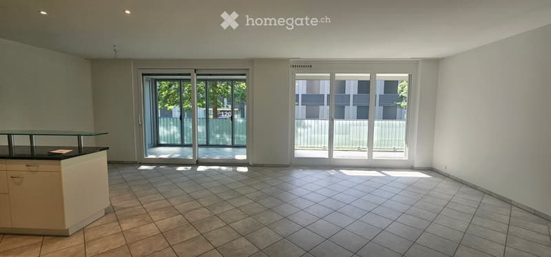 Empty room with tiled floor, white walls, and large sliding glass doors leading to a balcony.