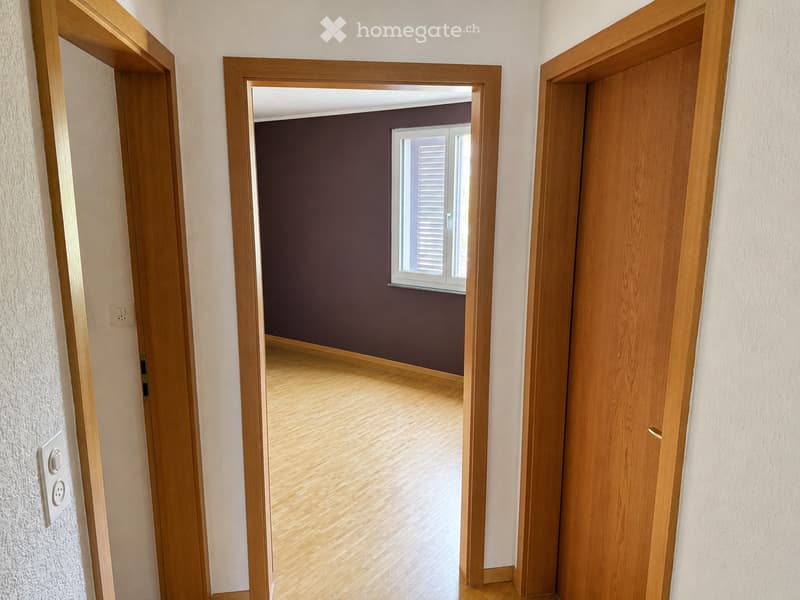 Unfurnished Room. Empty room with wooden flooring, dark walls, and a window with shutters. No furniture or equipment visible.