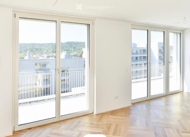 Empty room with large sliding glass doors leading to a balcony, wooden flooring, and white walls.