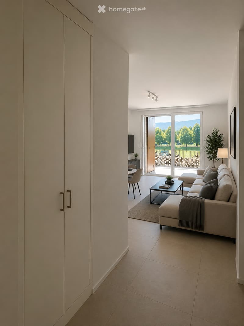 Modern living room with a beige sofa, coffee table, dining area, and large sliding glass doors leading to a scenic outdoor view.
