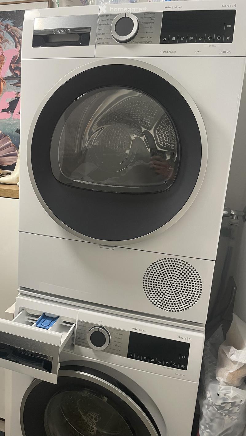 Modern Bosch washing machine and dryer combo unit with digital control panels and sleek design.