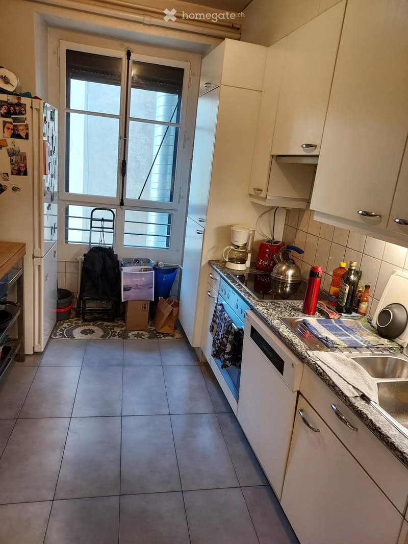 Modern kitchen with white cabinets, granite countertop, stainless steel appliances, and a windowed door leading to a balcony.