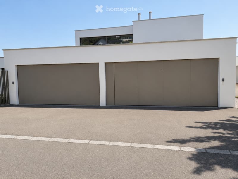 Modern two-story house with white exterior, large garage doors, and clean lines.