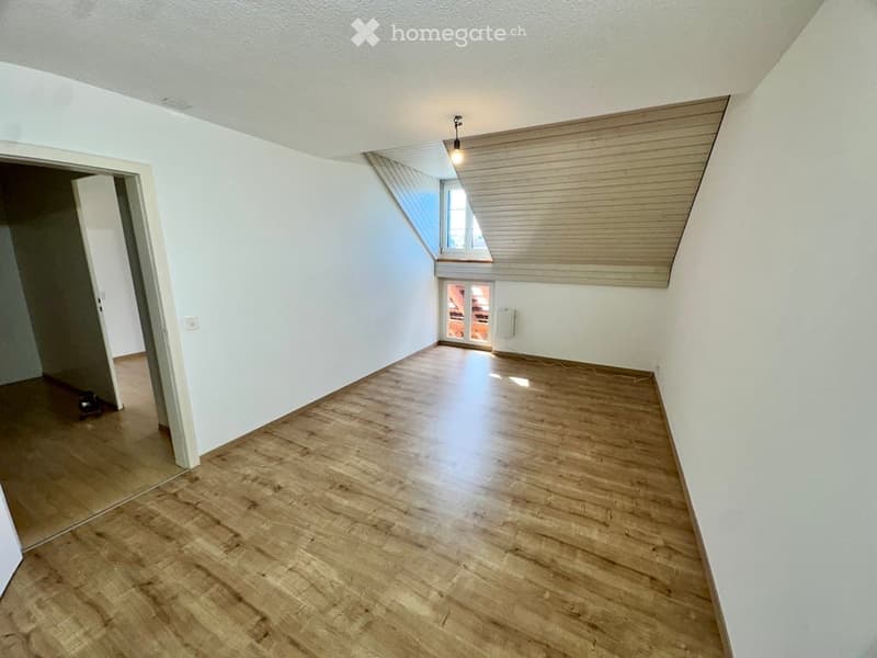 Empty room with wooden flooring, white walls, and a skylight window. No furniture or equipment present.