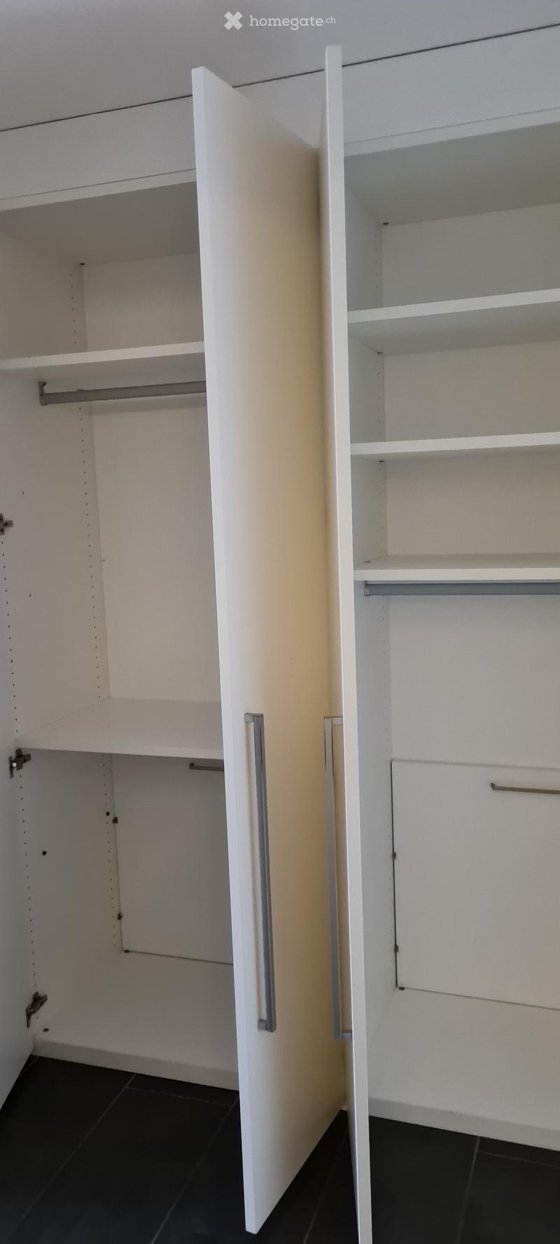 Empty closet with white walls, shelves, and a hanging rod, no furniture or items present.