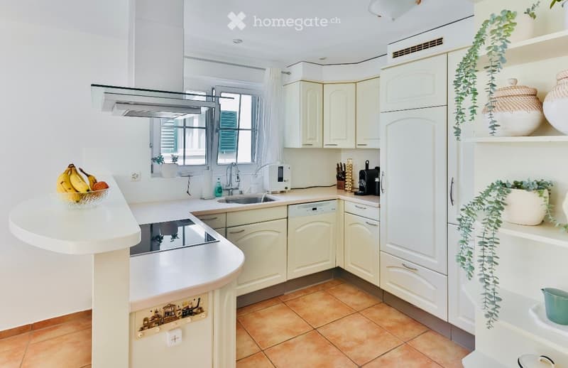 white cabinets, tiled floor, white countertop, electric stove, sink, dishwasher, microwave, refrigerator, plates, pots, bowls, bananas