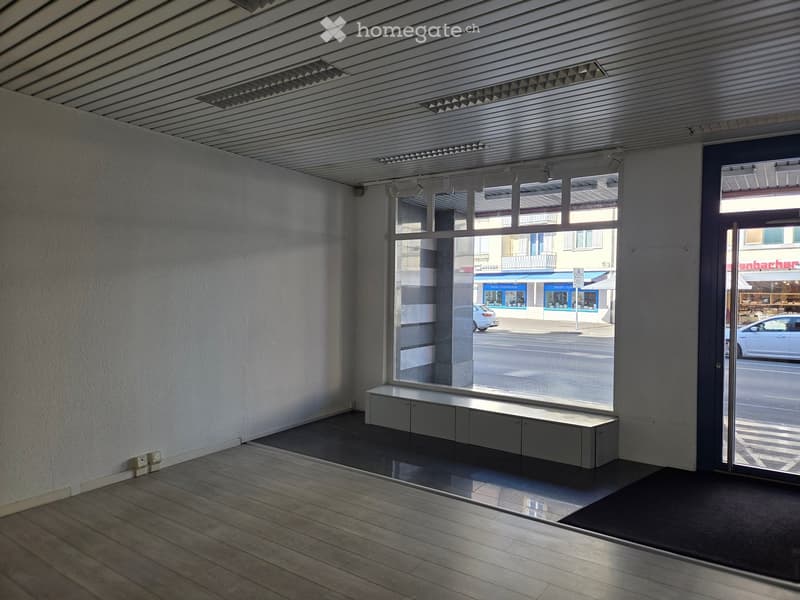 empty room, white walls, wooden floor, large window, bench, ceiling lights