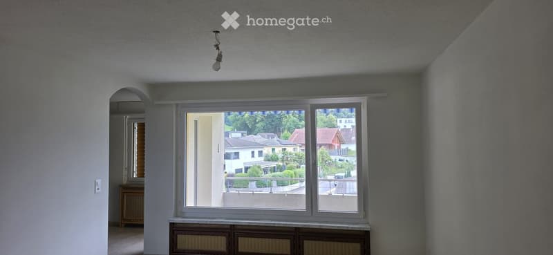 Empty room with large windows, white walls, and a simple light fixture. No furniture or equipment is present.
