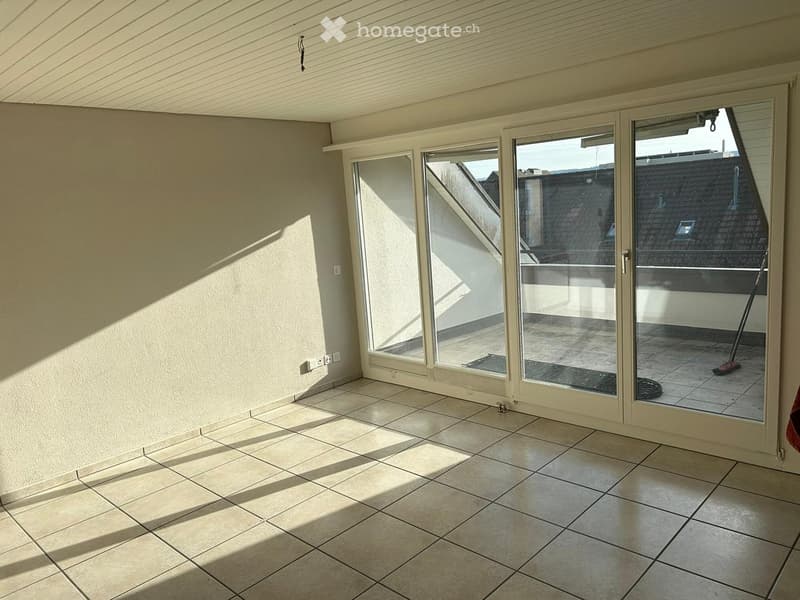 Empty room with tiled floor and large sliding glass doors leading to a balcony area.