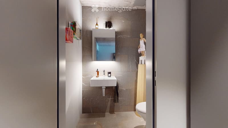 Modern bathroom with a white sink, mirror, and toilet. Features a sleek design with a wooden shelf and decorative items.