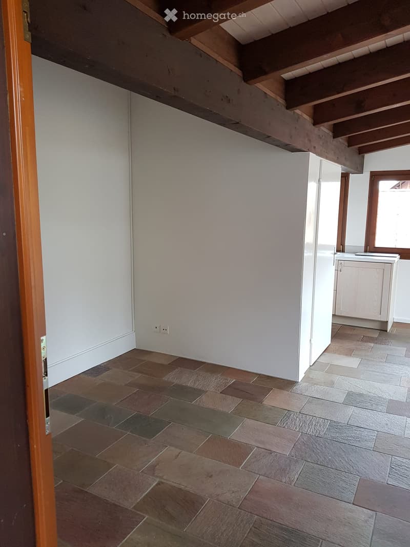 white walls, wooden beams, tiled floor, power outlets, small kitchen area with sink