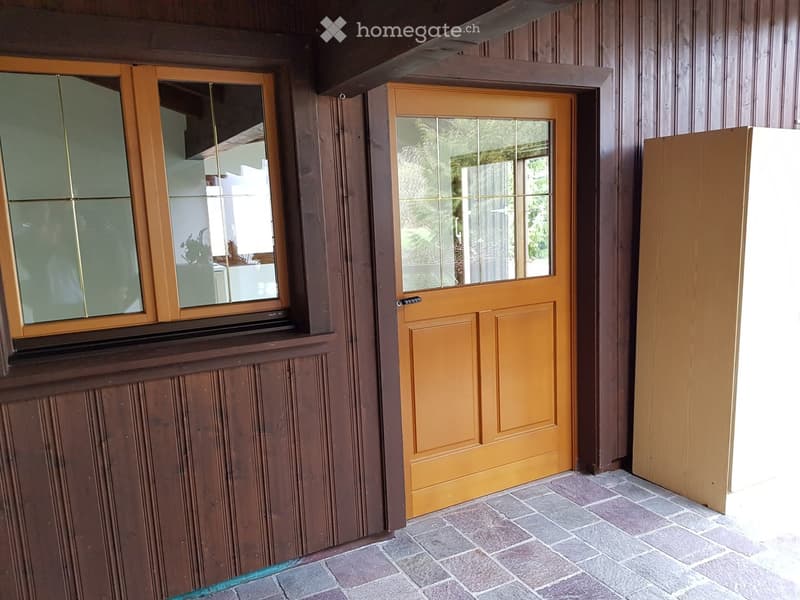 Wooden wall, brick ground floor, yellow double door, glass panel windows
