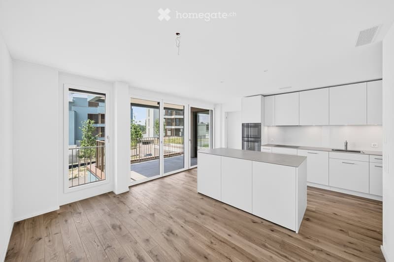 Modern kitchen with white cabinets, a central island, and large sliding glass doors leading to a balcony.