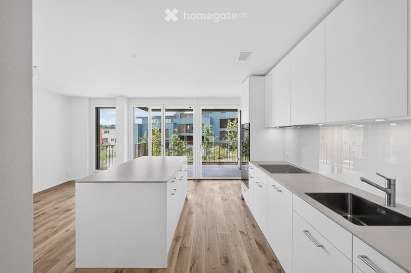 Modern, minimalist kitchen with white cabinets, light wooden flooring, and a central island. Large windows and sliding glass doors lead to a balcony.