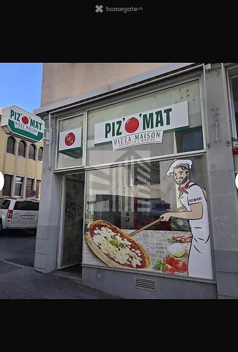 Facade of a pizza restaurant named "Piz' Mat" with large windows and a signboard. The storefront features a graphic of a chef holding a pizza and various toppings displayed on the window.